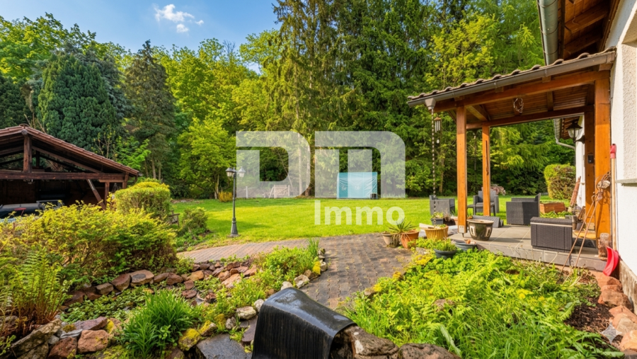Altengerechtes Wohnen mit Charme: Großzügiger Bungalow auf großem Grundstück + Nebengebäude - Gartenbereich vor dem Bungalow / Carport